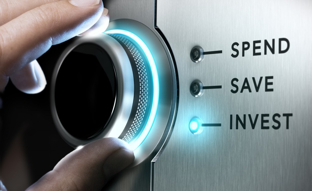 Man hand turning a knob in the invest position, Concept image for illustration of making an investment versus saving or spending money.