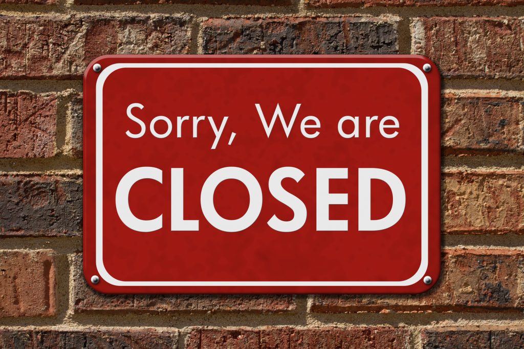 Sorry We are Closed Sign, A red hanging sign with text Sorry We are Closed on a brick wall